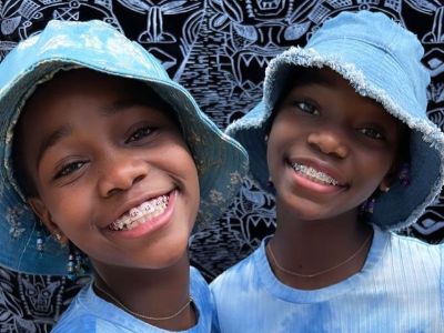 Stella and Estere Ciccone are wearing matching light blue colored outfits and a matching cap.